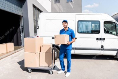 Livreur déchargeant des cartons de vin devant un établissement
